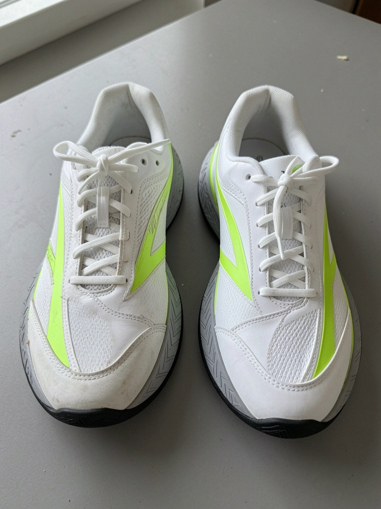 Três modelos de tênis Nike Vapor Pro enfileirados sobre fundo neutro, com detalhes em branco, azul e verde